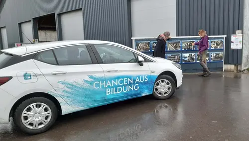 Ein Auto, das mit Slogan Chancen aus Bildung bedruckt ist