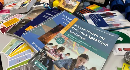 Eine Sammlung von Lehrbüchern und Lehrutensilien zu Autismus-Spektrum-Störungen